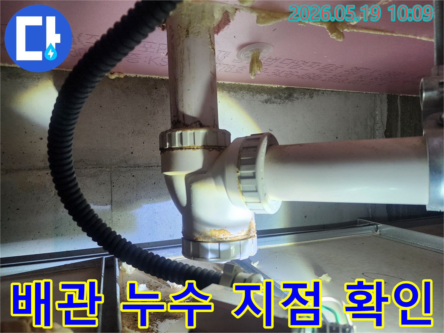 누수 엔지니어가 배관 연결부의 부식과 물기 흔적을 확인하며-누수 지점을 정확히 파악하기 위한 진단 작업을 수행하고 있습니다