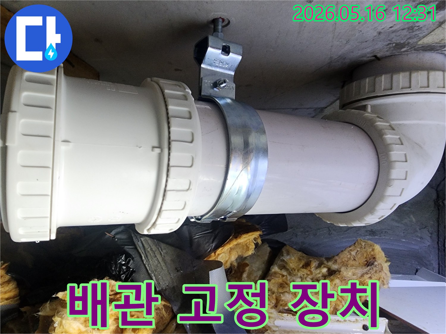 천장 콘크리트에 설치된 배관을-견고하게 지지하는 금속 클램프의 상세 이미지입니다.