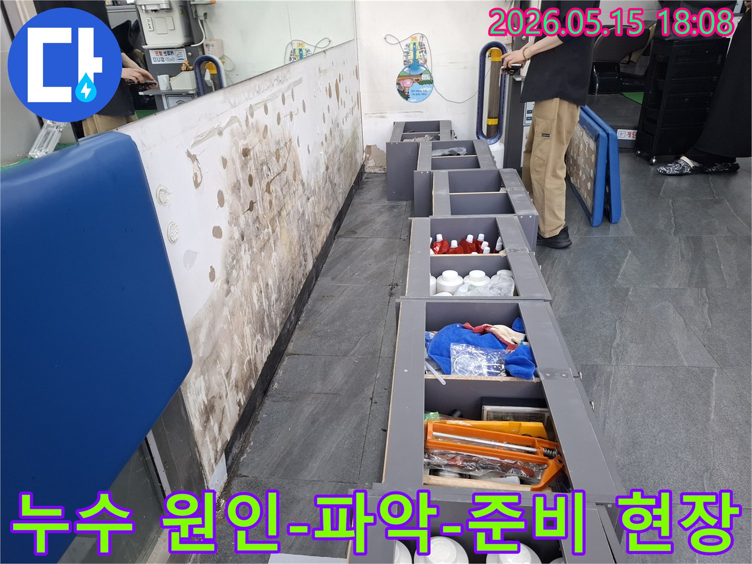 누수로 인한 벽면 손상과-주변 가구들을 정리한-탐지 준비 현장을-보여주는 이미지입니다