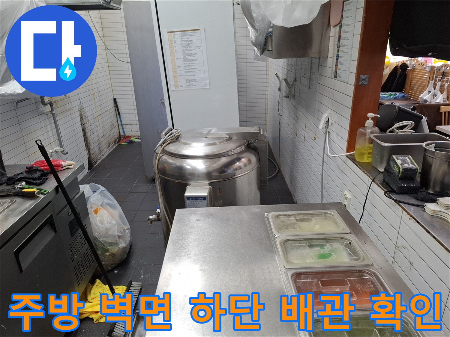 식당 주방 내부의 물기가 맺힌 벽면 하단부와 배관 연결 지점 촬영