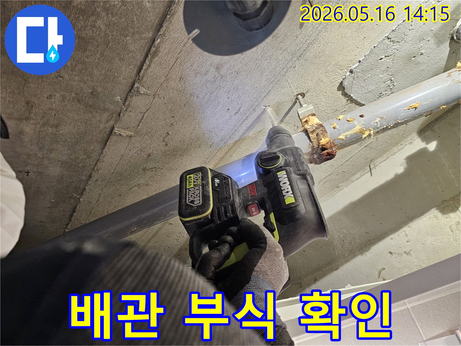 누수 전문가가 천장 배관의 부식 여부를 확인하기 위해 드릴로 콘크리트를 타공하는 모습-정확한 누수 진단을 위한 작업입니다.