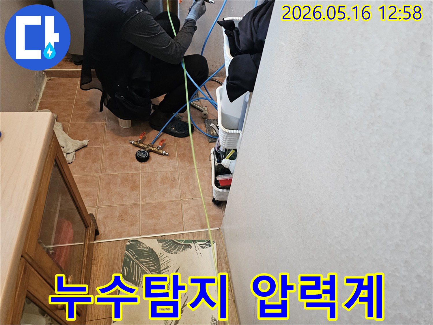 누수-탐지-전문가가-압력-측정-장비를-점검하며-누수-지점을-찾는-작업-사진