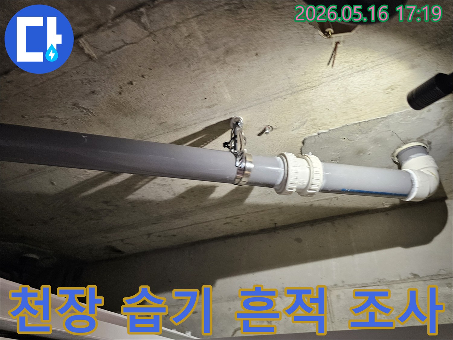 배관 주변의 콘크리트 천장에서-발견된 습기 흔적을-주의 깊게 조사하는-누수 탐지 전문가의 모습