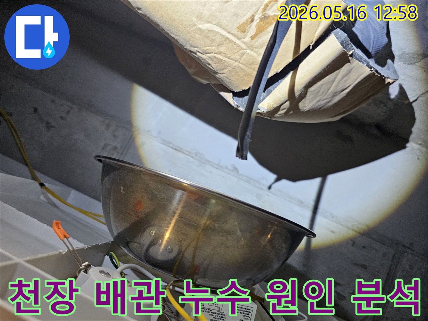 어두운 천장 속에서-강력한 조명으로-배관의 미세한 누수 지점을-정밀하게 분석하는-전문가의 모습입니다