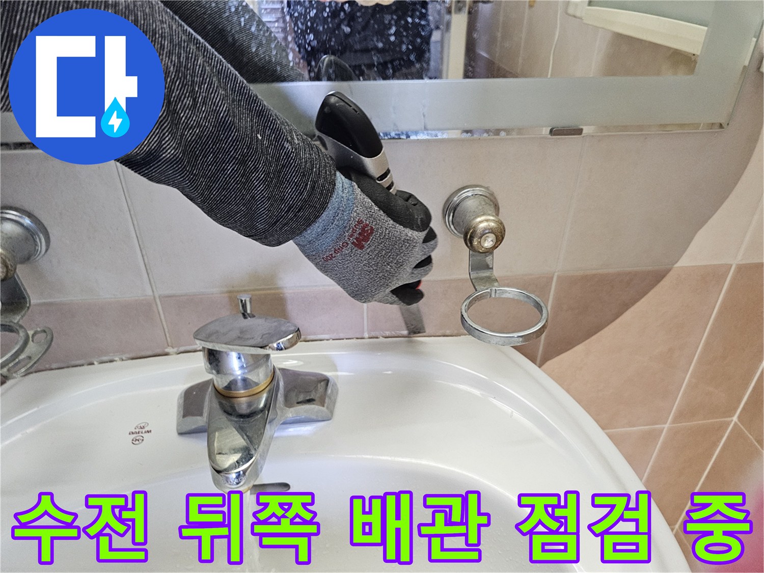 작업자가 전동 공구를 이용해 세면대 수전과 벽면 배관의 밀착 상태를 확인합니다.