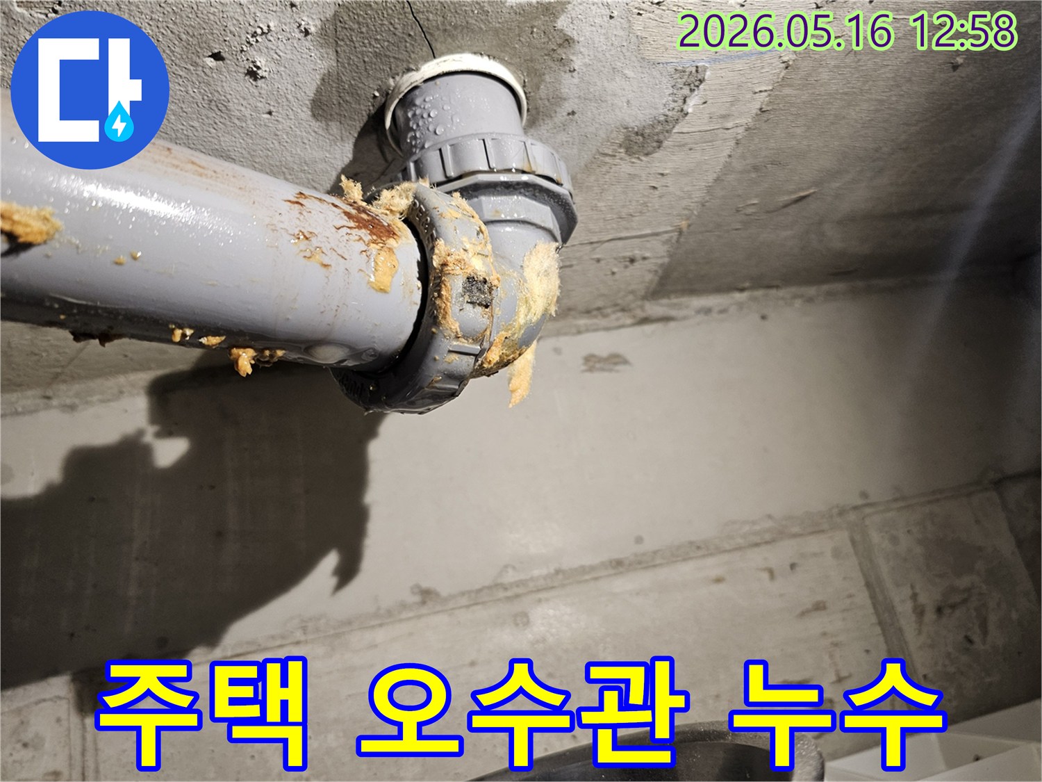 주택-천장-아래-오수관-연결부에서-물이-새어-나와-주변-단열재가-젖은-모습을-보여주는-누수-현장-사진