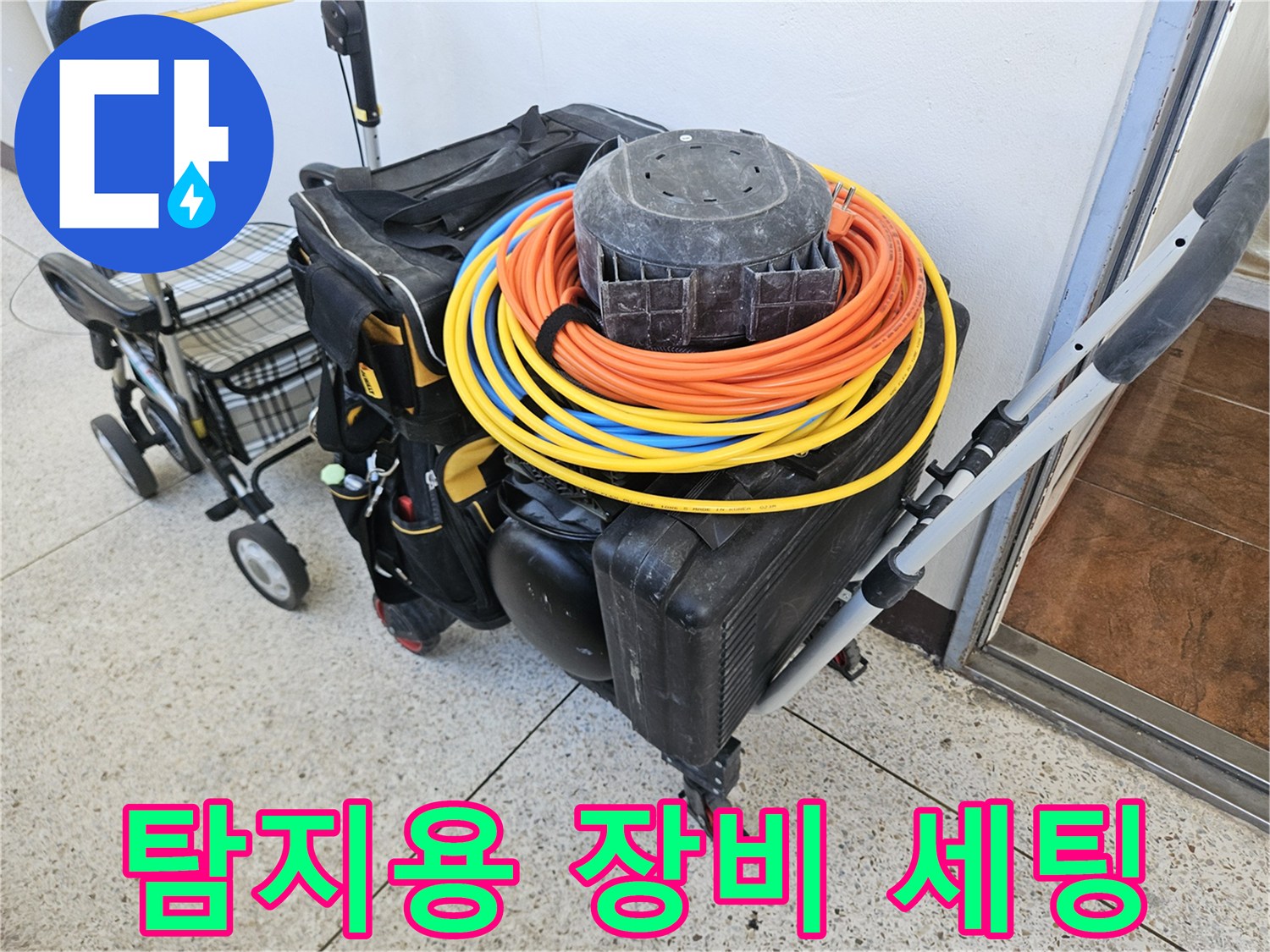 노란색 전선 릴과 검정색 공구 케이스가 놓인 현장 모습