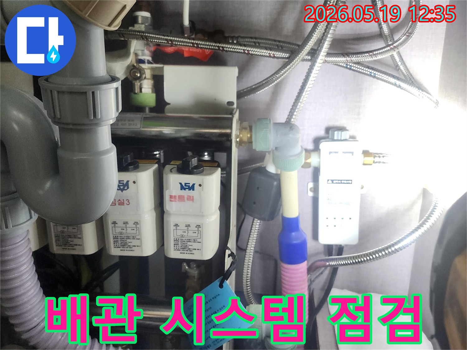 누수 문제를-해결하기 위해-복잡하게 연결된-수도 배관과-정수 장치를-전문가가-면밀히-살펴보는-장면입니다.