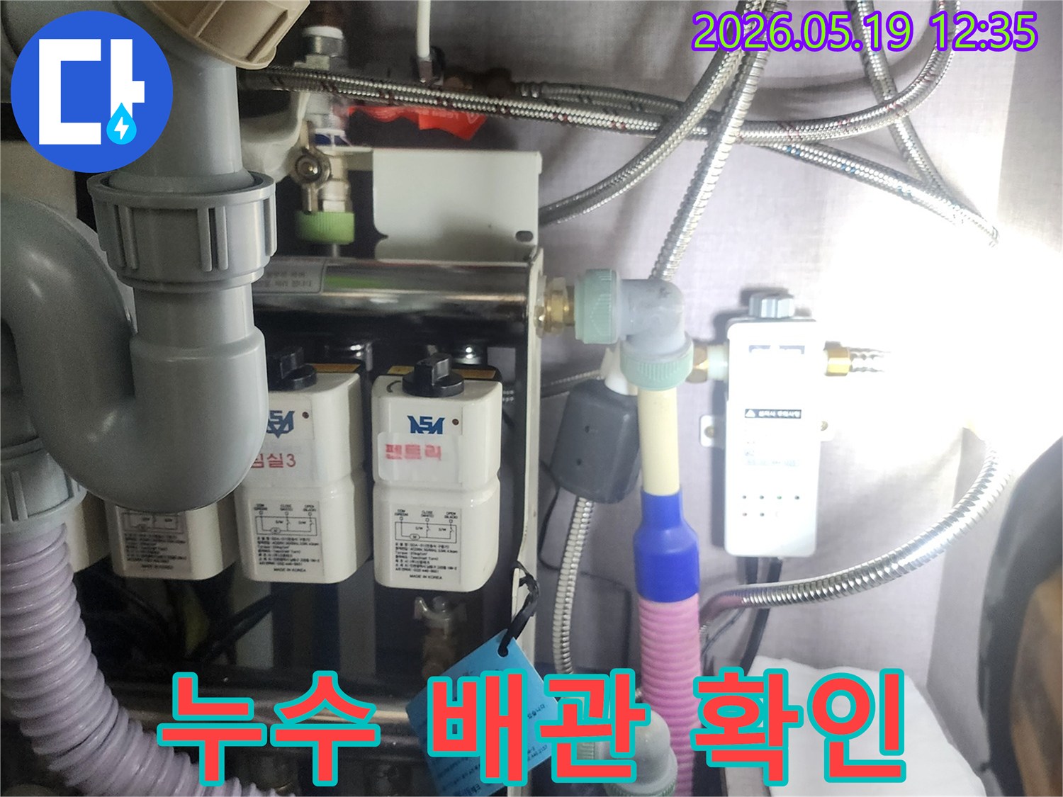 누수 탐지 전문가가-복잡하게 연결된-수도 배관과-정수 장비를-정밀하게-확인하는-과정을-담은 사진입니다.