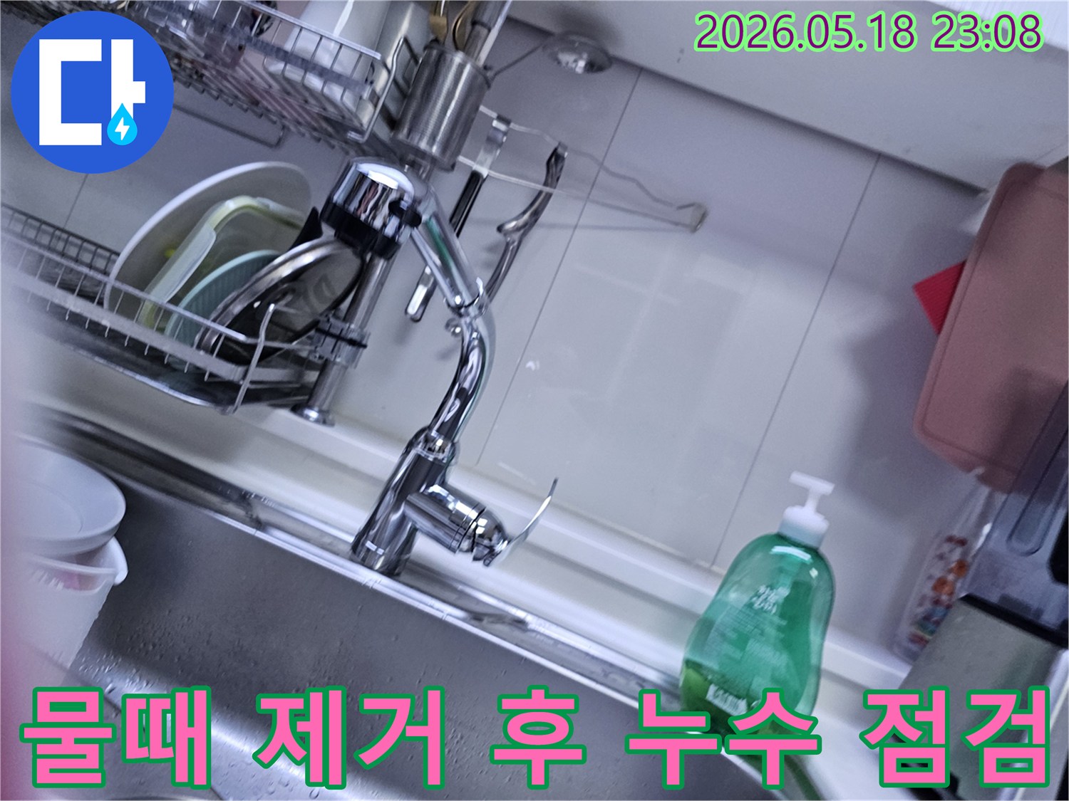 싱크대 주변의 물때를 제거한 후-발견된 누수 흔적을-확인하며-청소 과정 중 발생한-손상 여부를 진단하는 모습