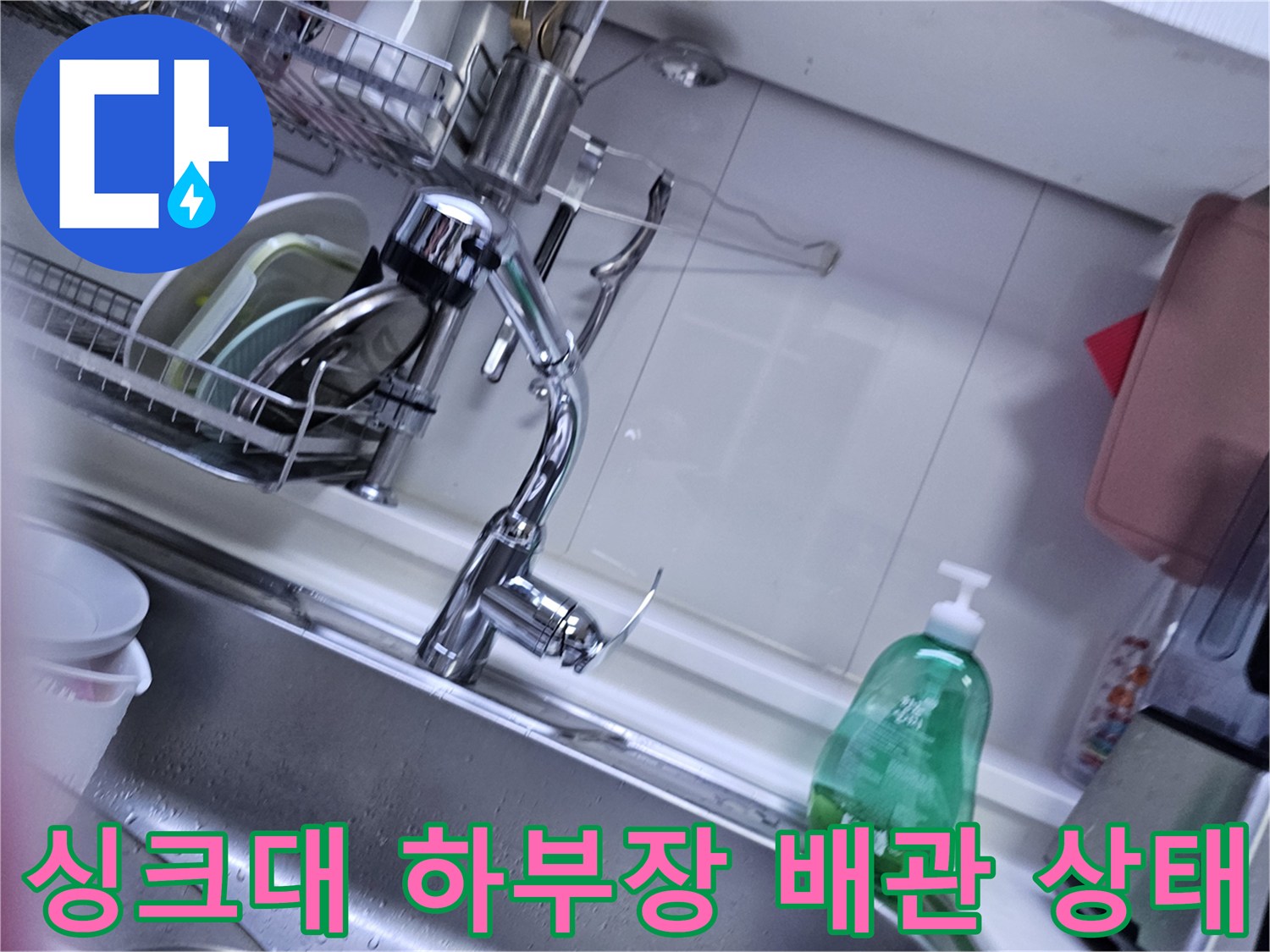 오산 주방 싱크대 하부장 내부의 배수 배관과 수전 연결 부위 모습