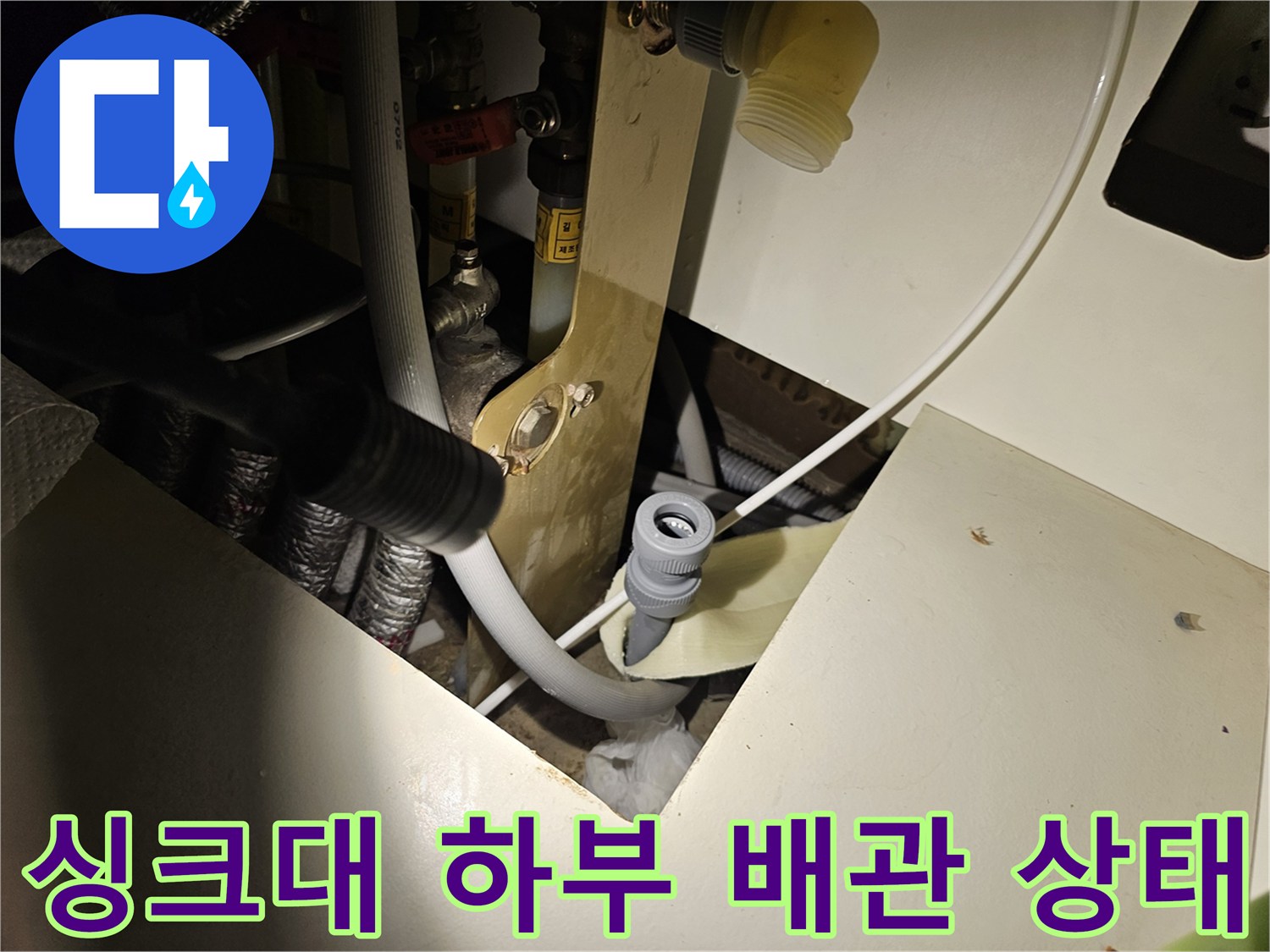 주방 싱크대 하부장 내부의 배수 배관과 연결 부위 모습입니다.