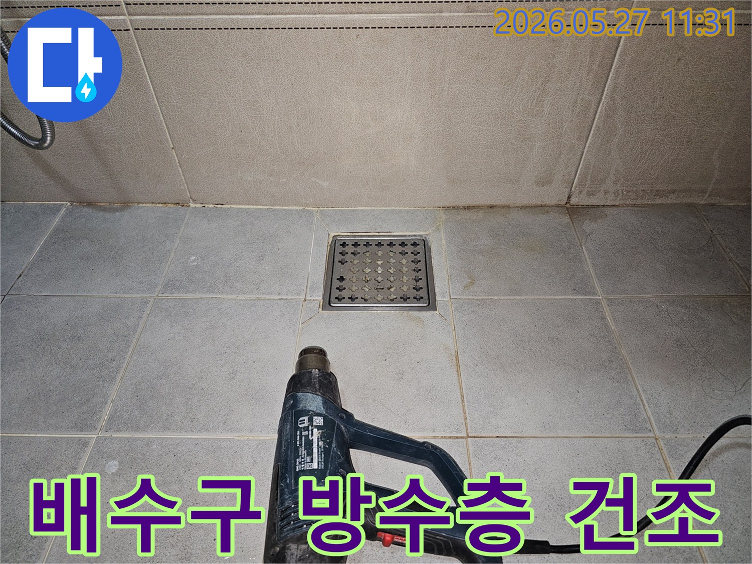 누수 엔지니어가-욕실 배수구 주변의-방수층 점검을 위해-열풍기로 건조하고 있습니다