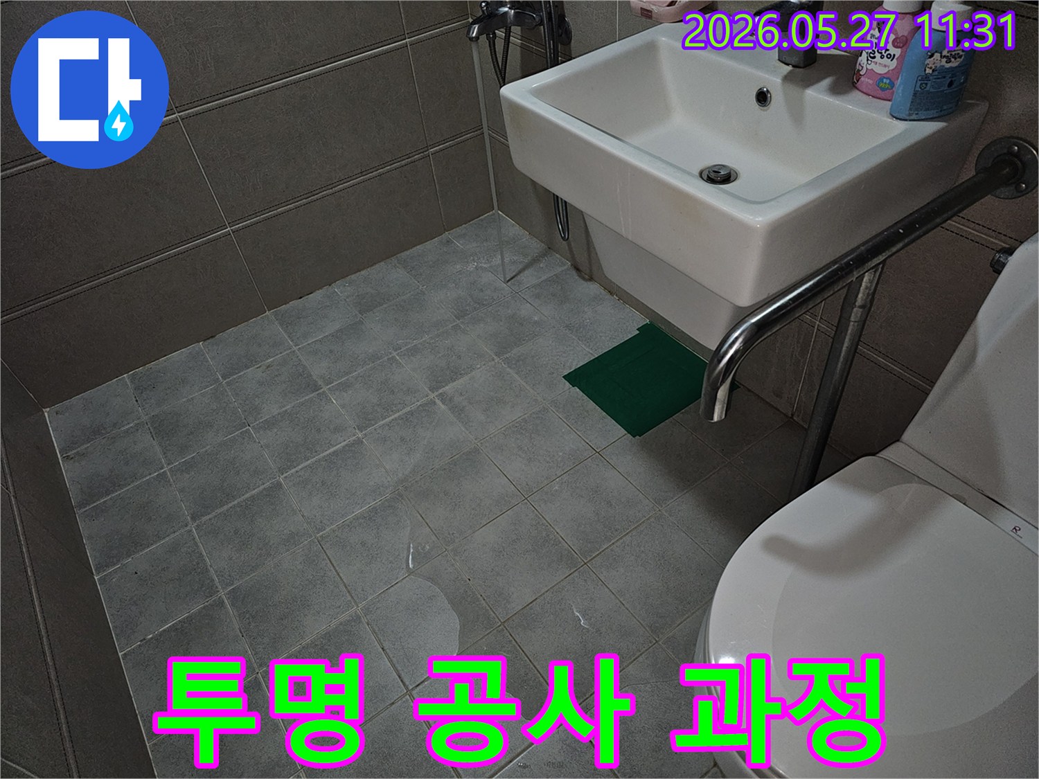 욕실 바닥 타일 위에-물이 고여 있는-누수 현장을-투명한 공사 과정을 위해 기록한 사진입니다.