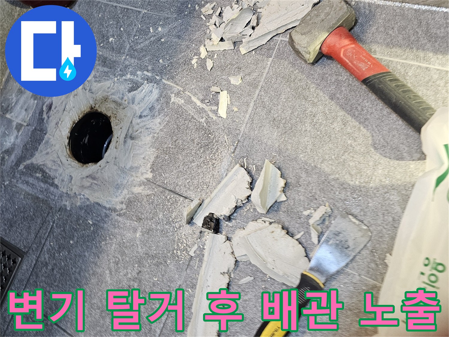 변기를 탈거하여 드러난 오수관 주변의 파손된 타일과 배관 상태입니다.