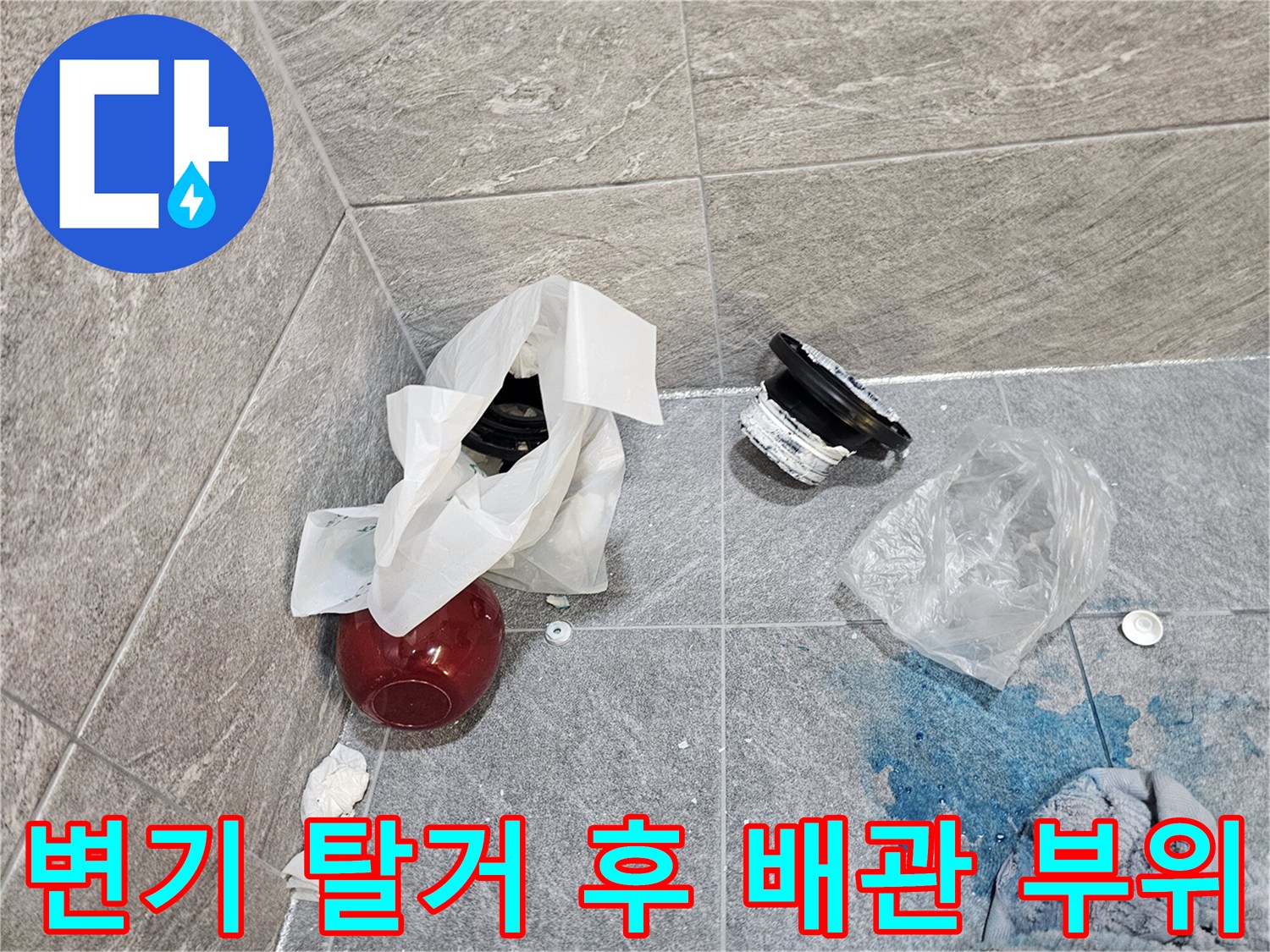 욕실 바닥 타일 위에 놓인 변기 탈거 부속과 오수관 주변의 습한 상태