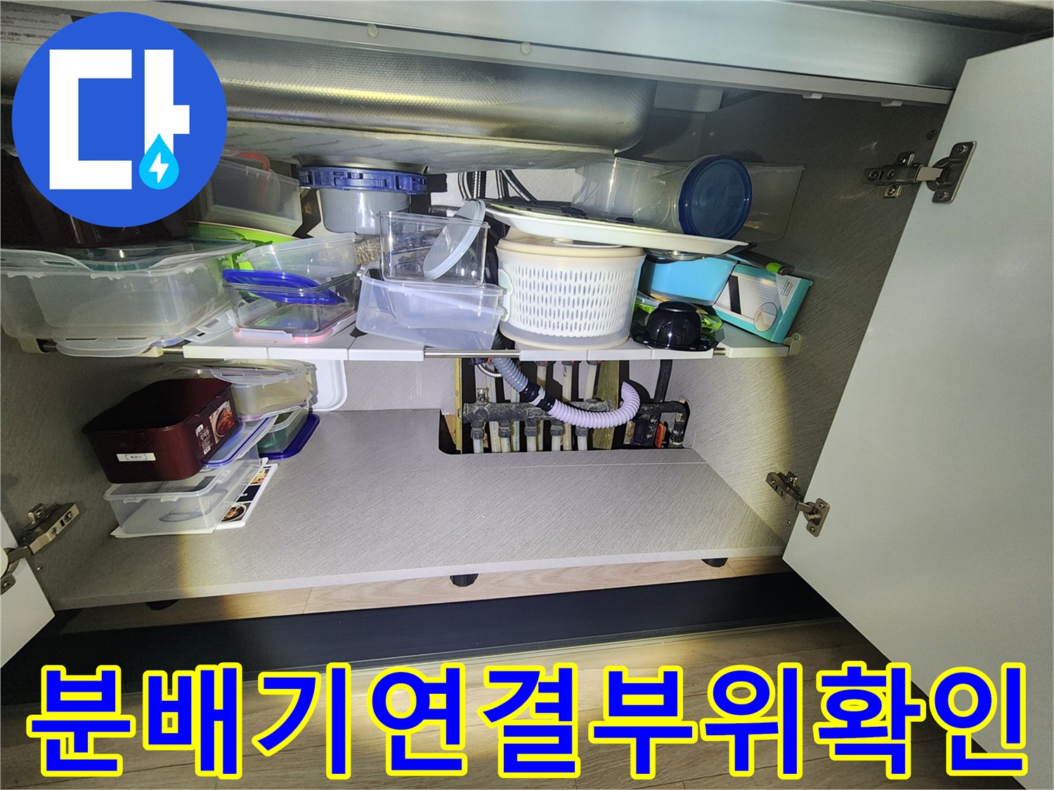 싱크대 밑 분배기 밸브와 배관 연결 부위 근접 촬영