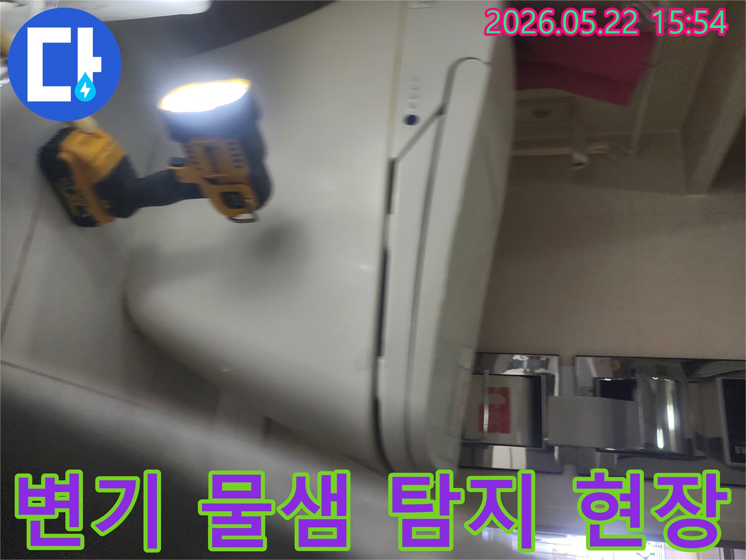용인 보정동 화장실에서-변기 주변의 물샘 현상을-정확히 탐지하기 위해-작업등을 비추며-세밀하게 점검하는-누수 전문가의 모습