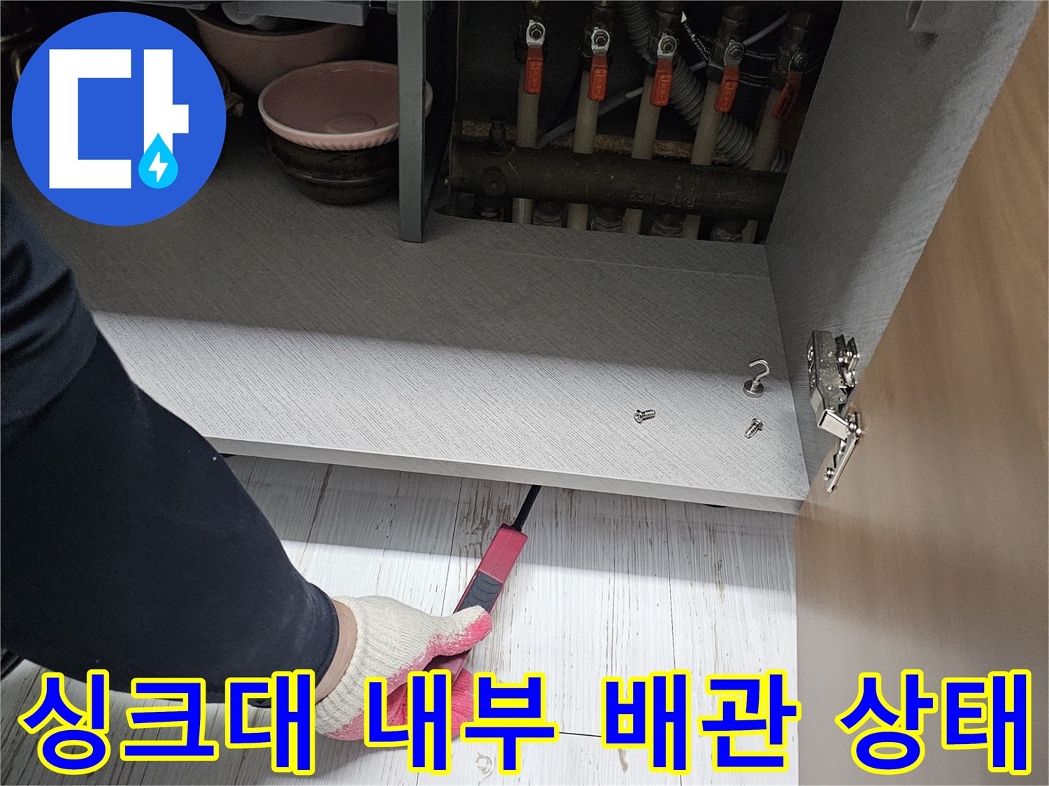 싱크대 하단 배관 구조와 밸브가 드러난 현장 이미지입니다.