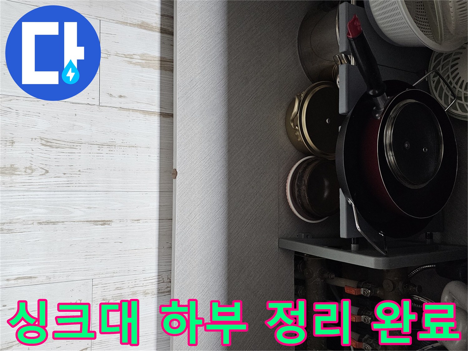 하부장 수납물을 치우고 배관 점검을 위해 비워진 주방 내부 모습입니다.