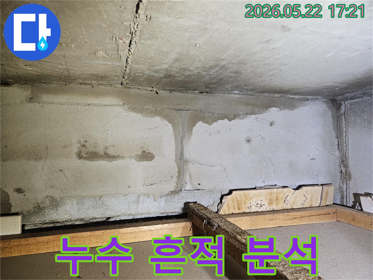천장 콘크리트와 벽면의 이음새에서 물이 흘러내려-심각한 물자국과 얼룩을 남긴-누수 피해 현장의 전반적인 모습