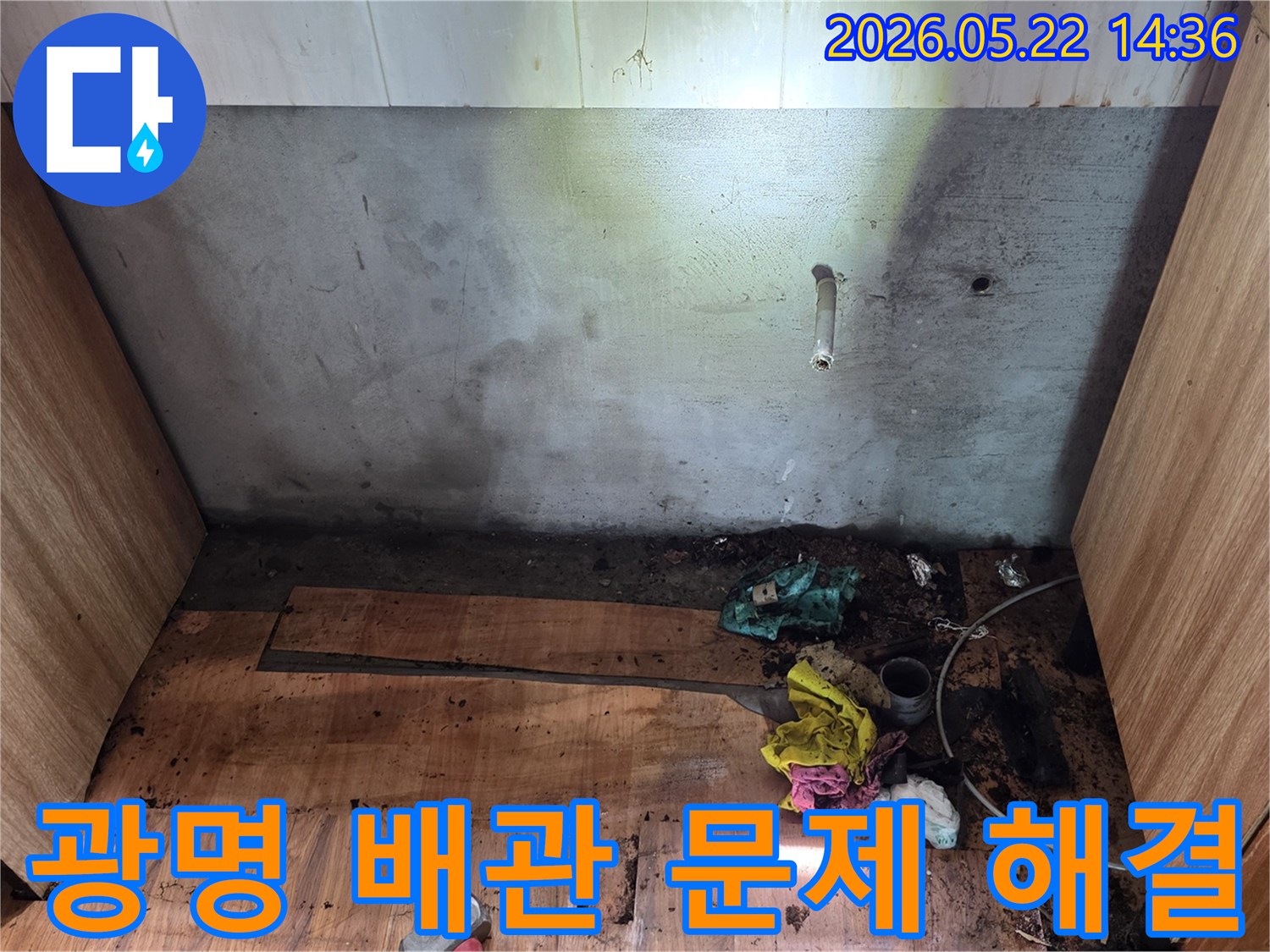 광명시 명지그린하우스텔에서-벽면 배관 주변과 바닥에 나타난-누수 흔적을-전문가가 배관 문제 해결을 위해-정밀하게 점검하는 모습