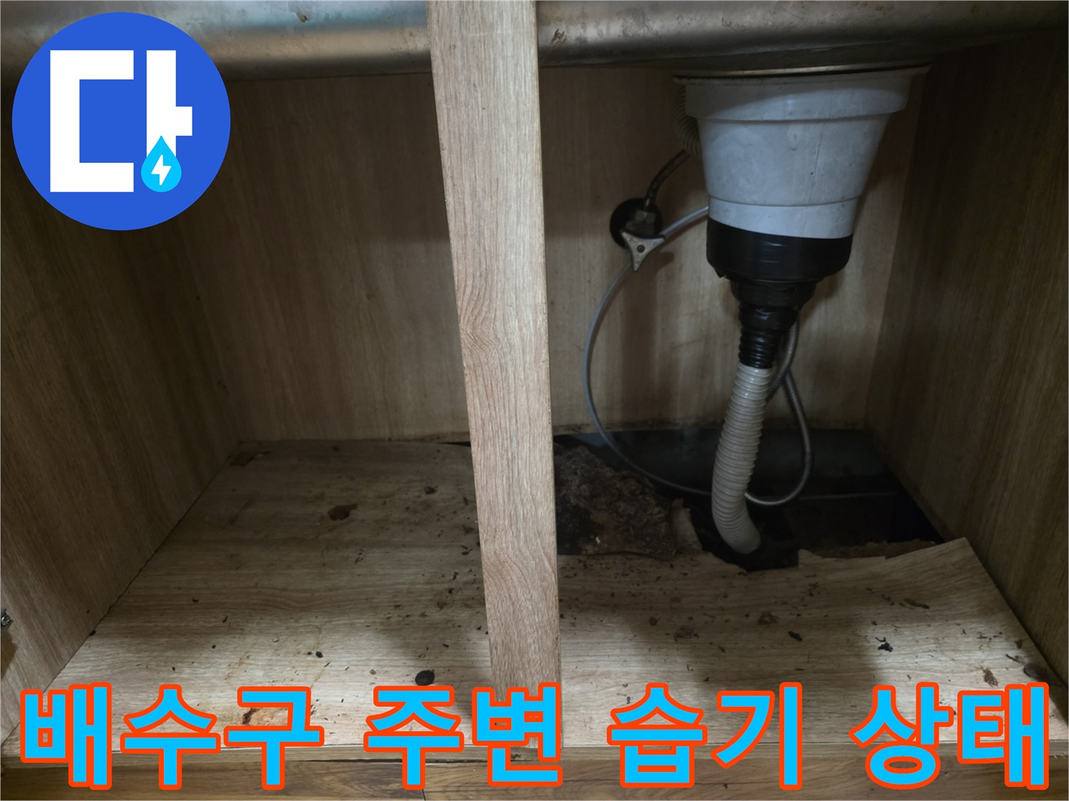 싱크대 하부장-젖어 있는 바닥판과 배수 호스 사진