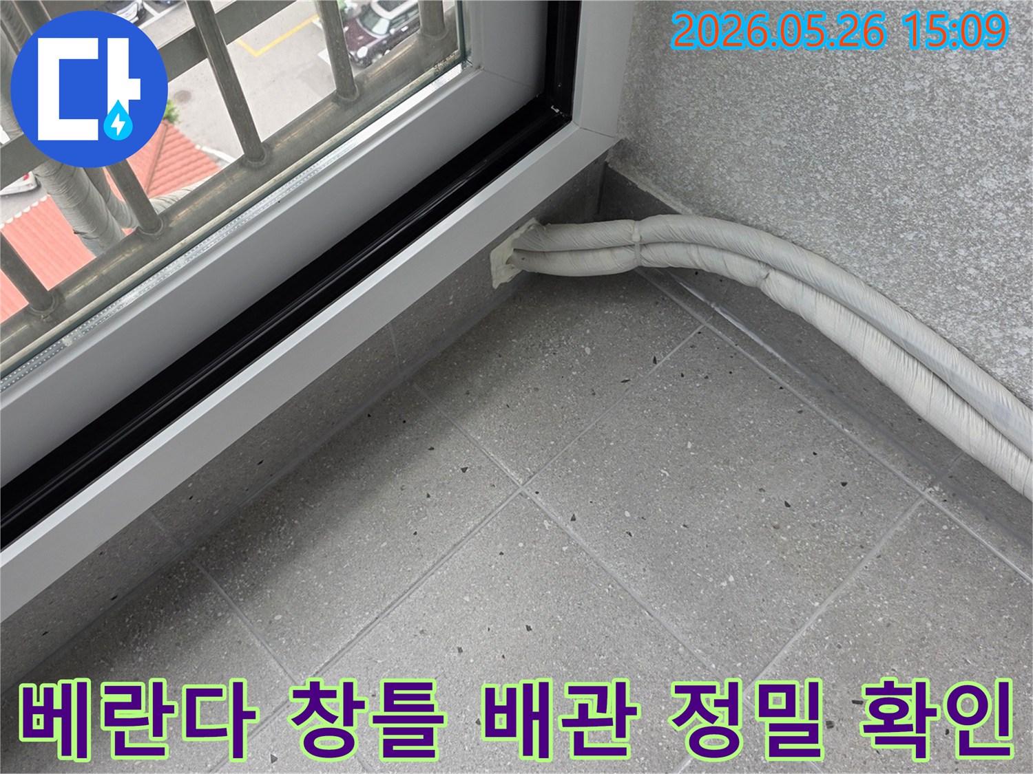 아파트 베란다 창틀과-벽면이 만나는 지점에서-배관 주변의 누수 여부를-면밀히 확인하고 있습니다