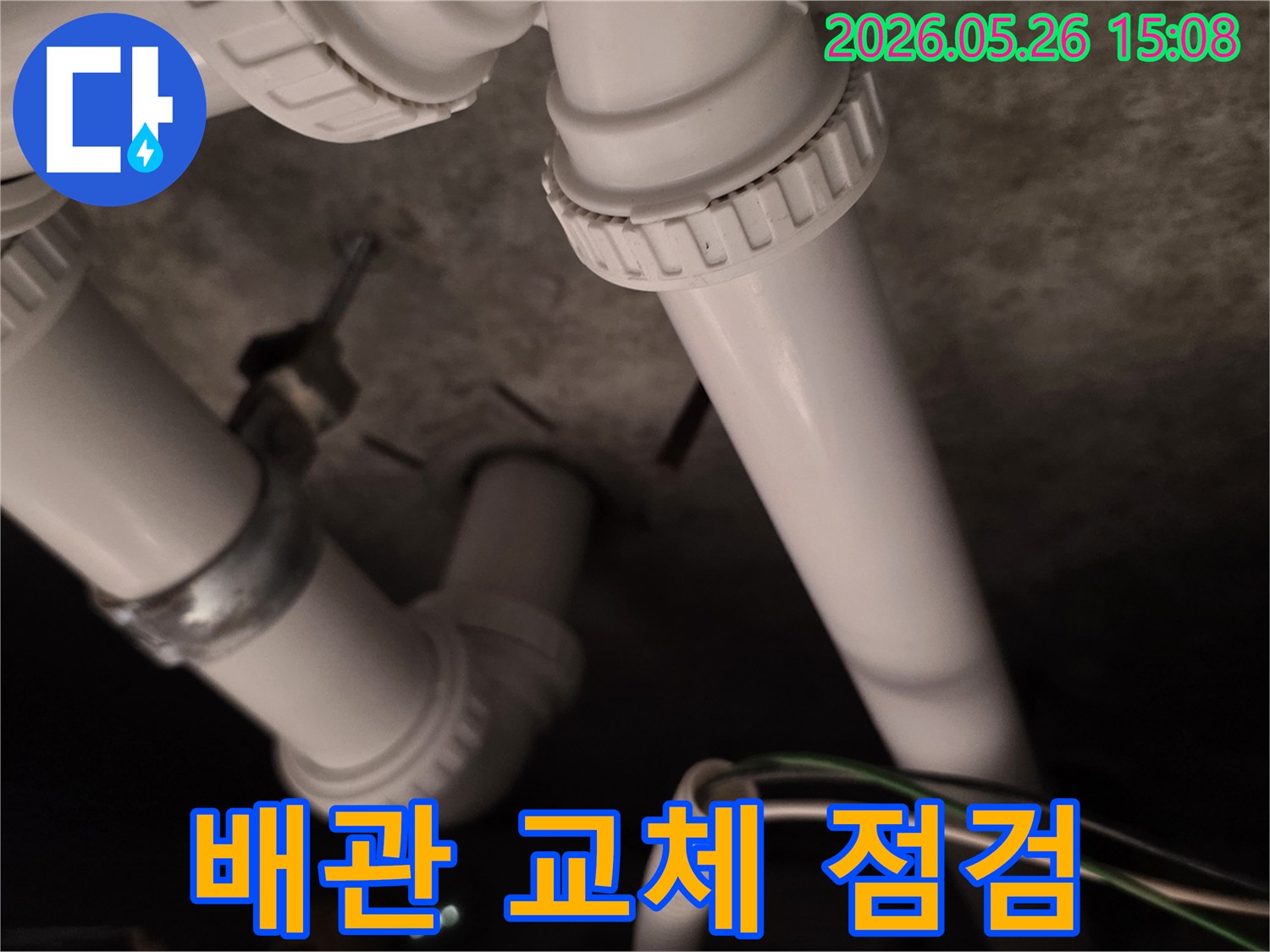 이 사진은-싱크대 배관 교체 작업을-마친 후-새 배관의 연결 상태를-최종적으로 점검하는-모습입니다.