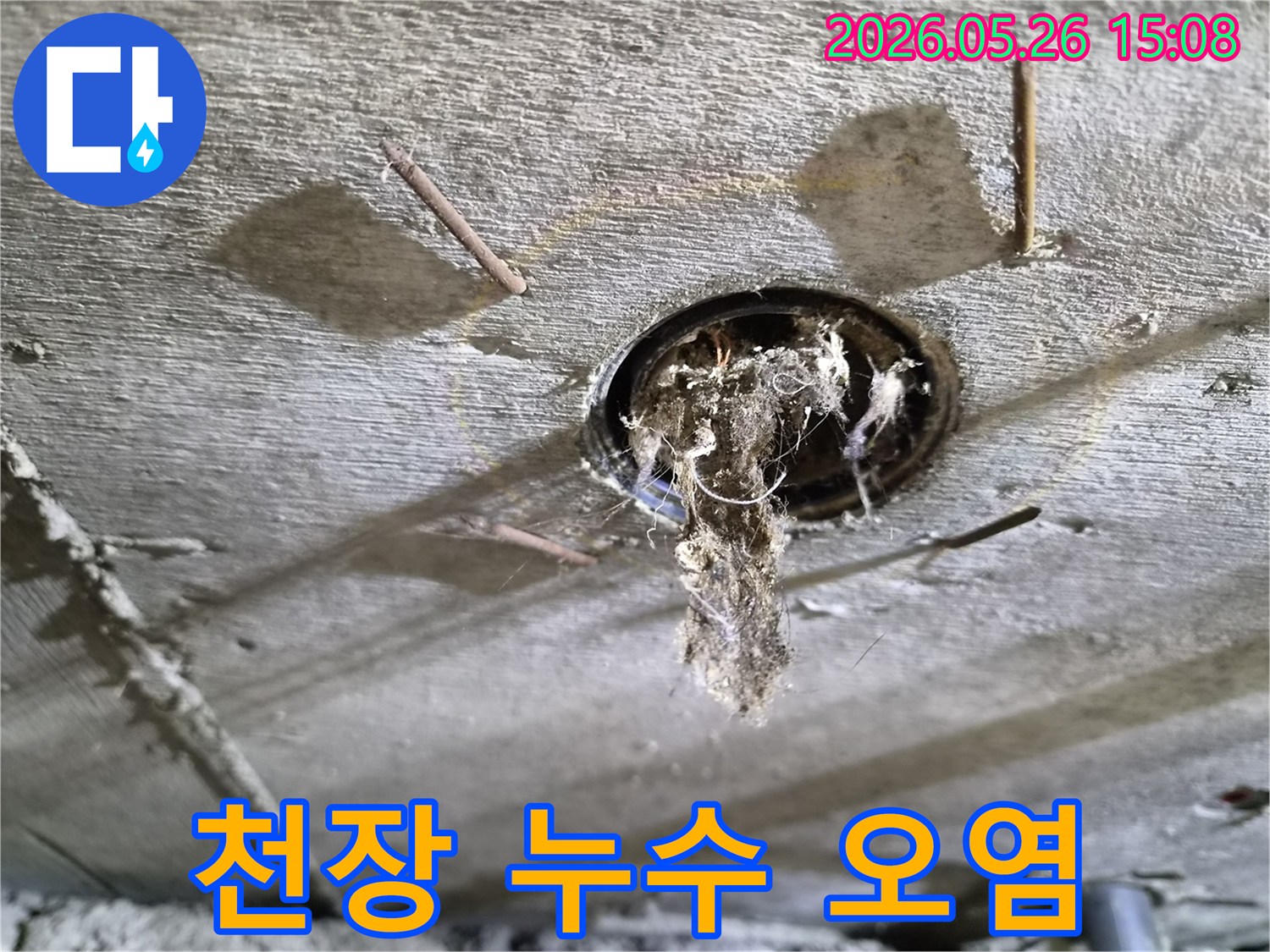 콘크리트 천장 구멍에서-심각하게-오염된-이물질이-떨어지는-누수-현장의-모습을-보여주는-사진