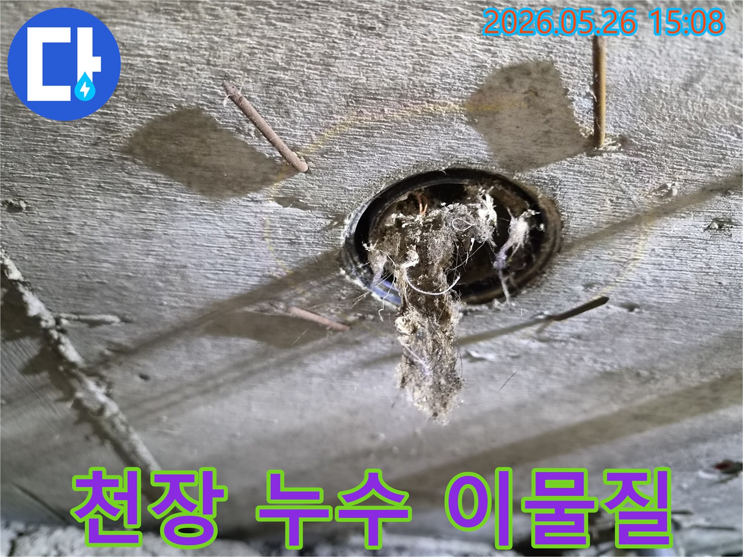 콘크리트 천장 구멍에서-오래된 이물질과-곰팡이가-떨어지는-모습을-보여주는-누수-현장-사진
