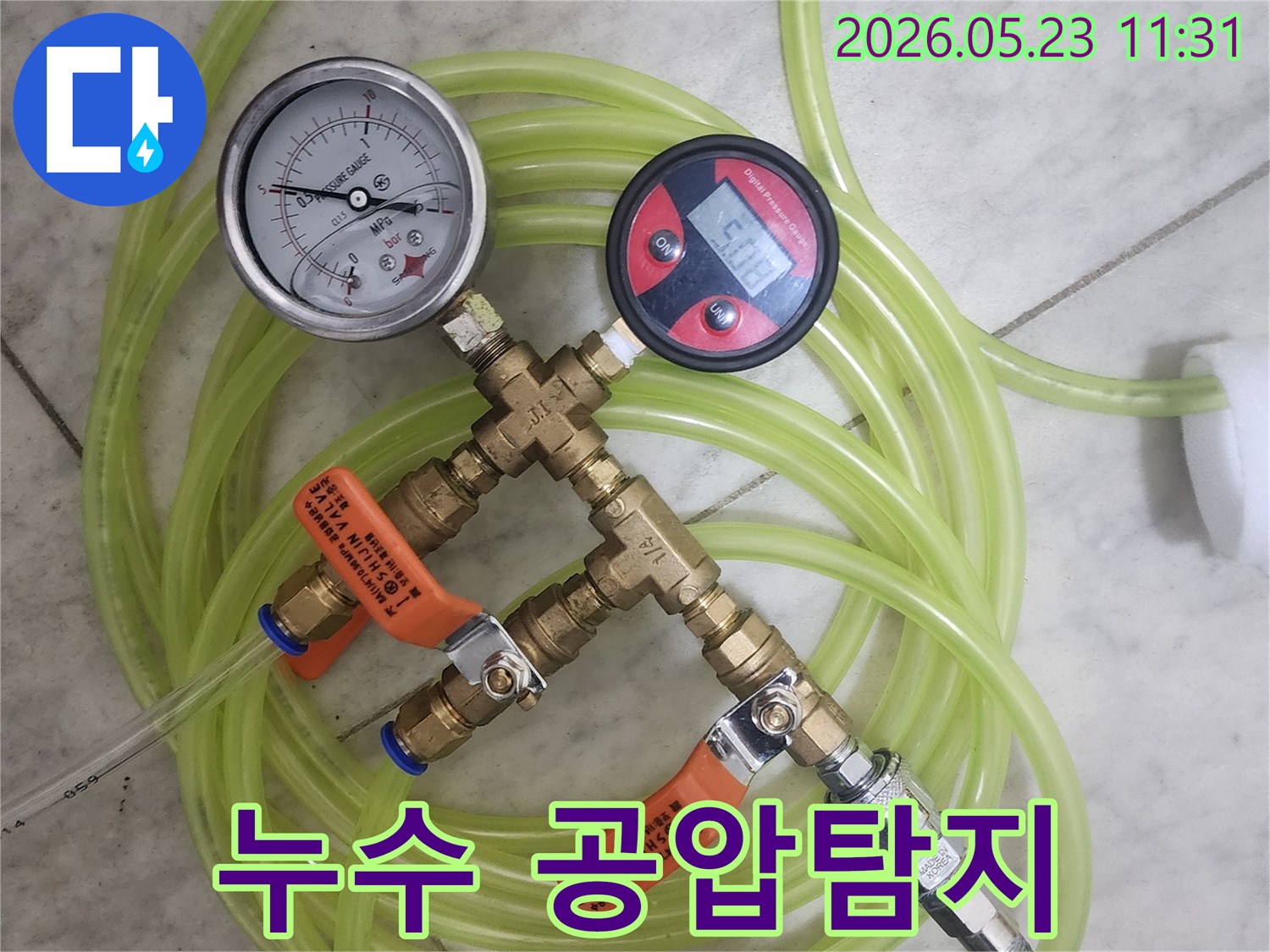 누수-탐지를-위해-배관에-연결된-공압-검사-장비의-게이지-확인-모습