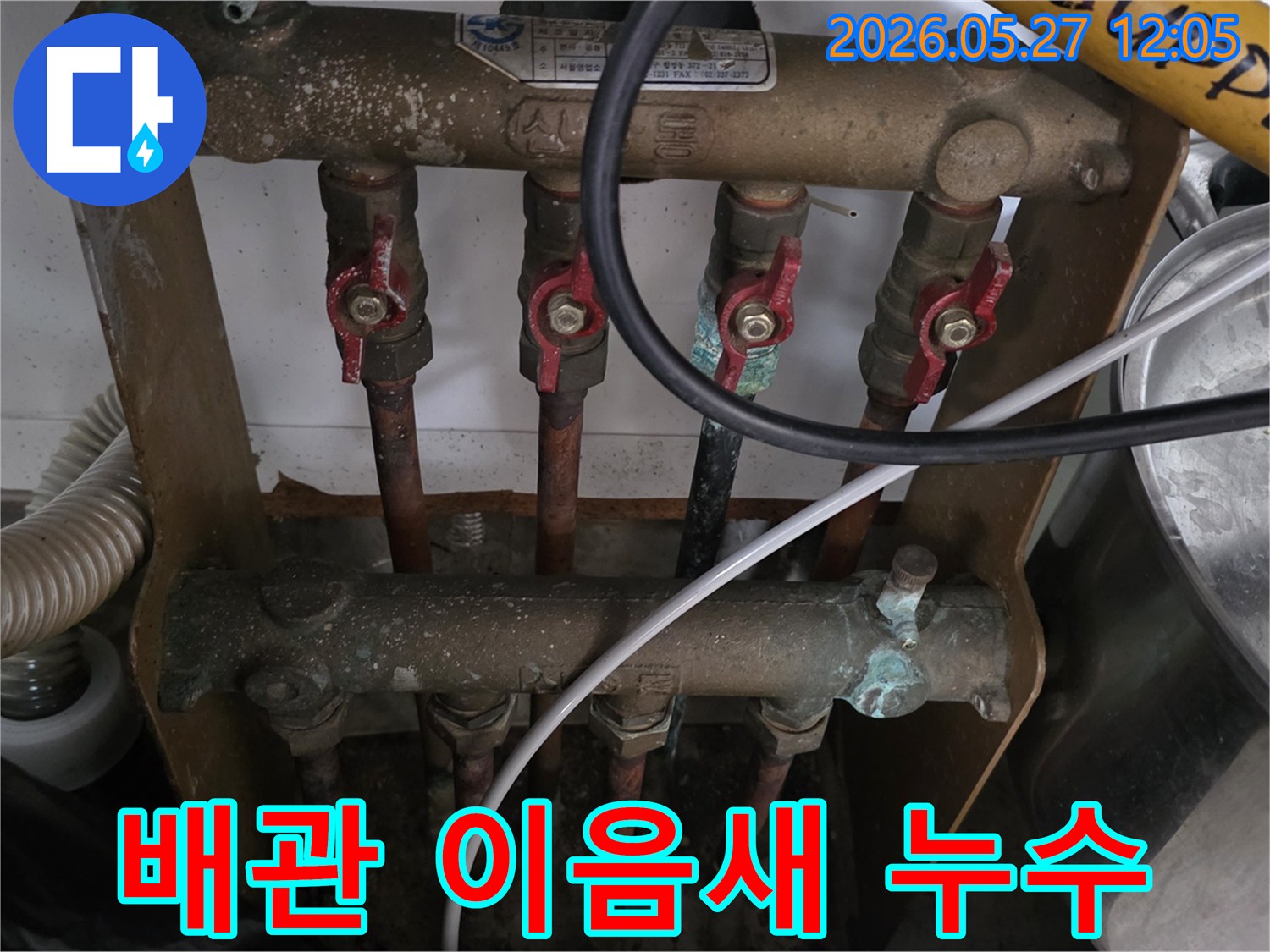 오래된 아파트의 보일러 분배기 배관-이음새에서 누수가 발생하여-전문가가 점검하고 있는 모습입니다