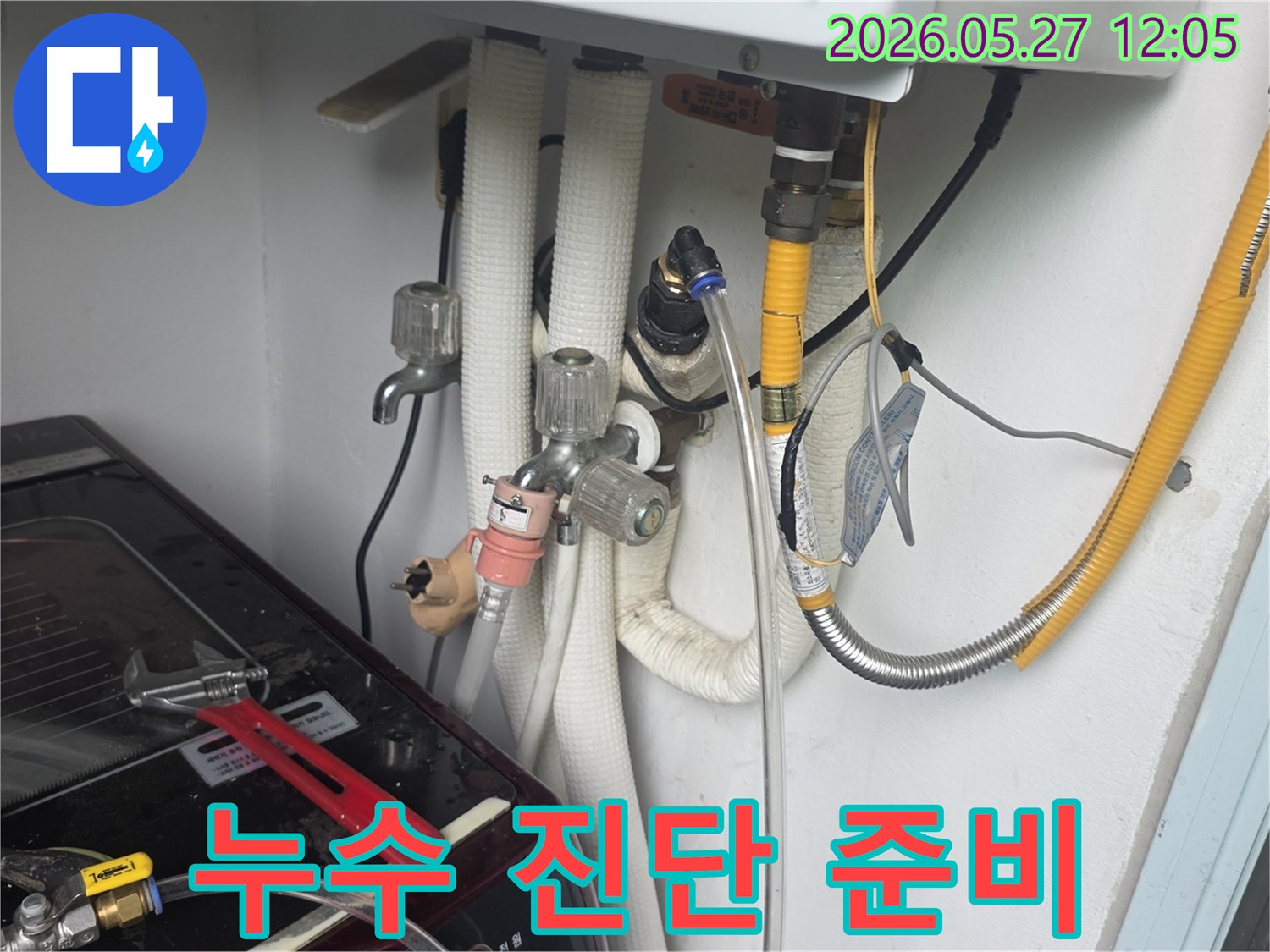 이 사진은-동두천 아파트에서-정확한 누수 진단을 위해-전문가가-탐지 장비를-준비하고-배관을 확인하는-모습입니다