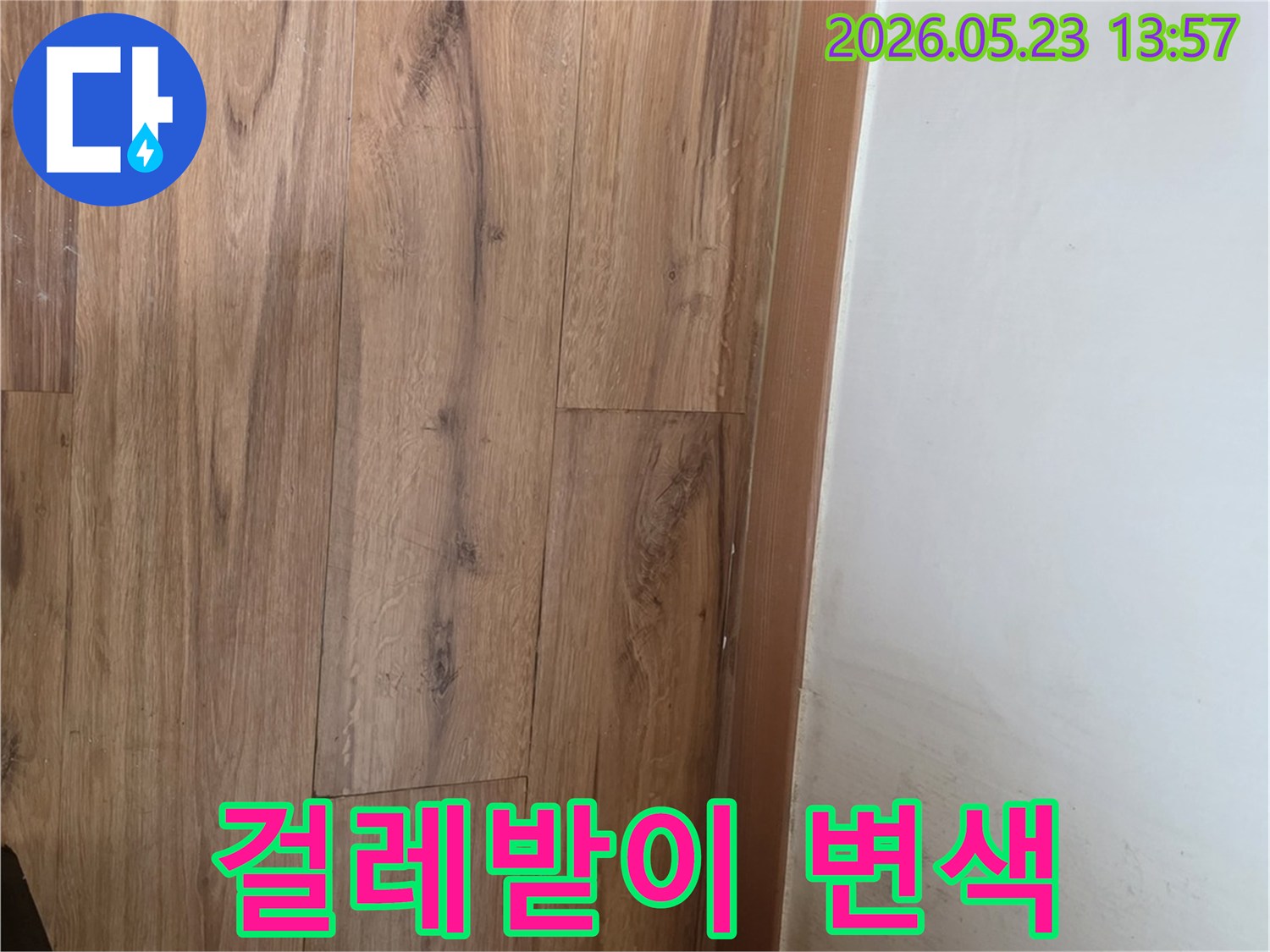 벽면과-마루-사이의-걸레받이가-누수로-인해-변색된-모습을-촬영한-사진입니다.