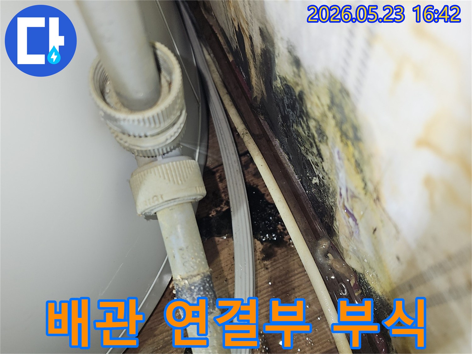 배관 연결부의 부식으로 인해-물이 새고 주변에 심각한 오염이 발생한-누수 현장 사진입니다.