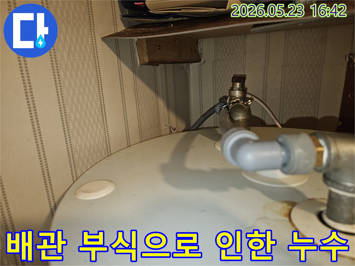 부식된-온수기-연결-배관에서-물이-새어-나와-주변에-얼룩이-생긴-상태를-보여주는-사진