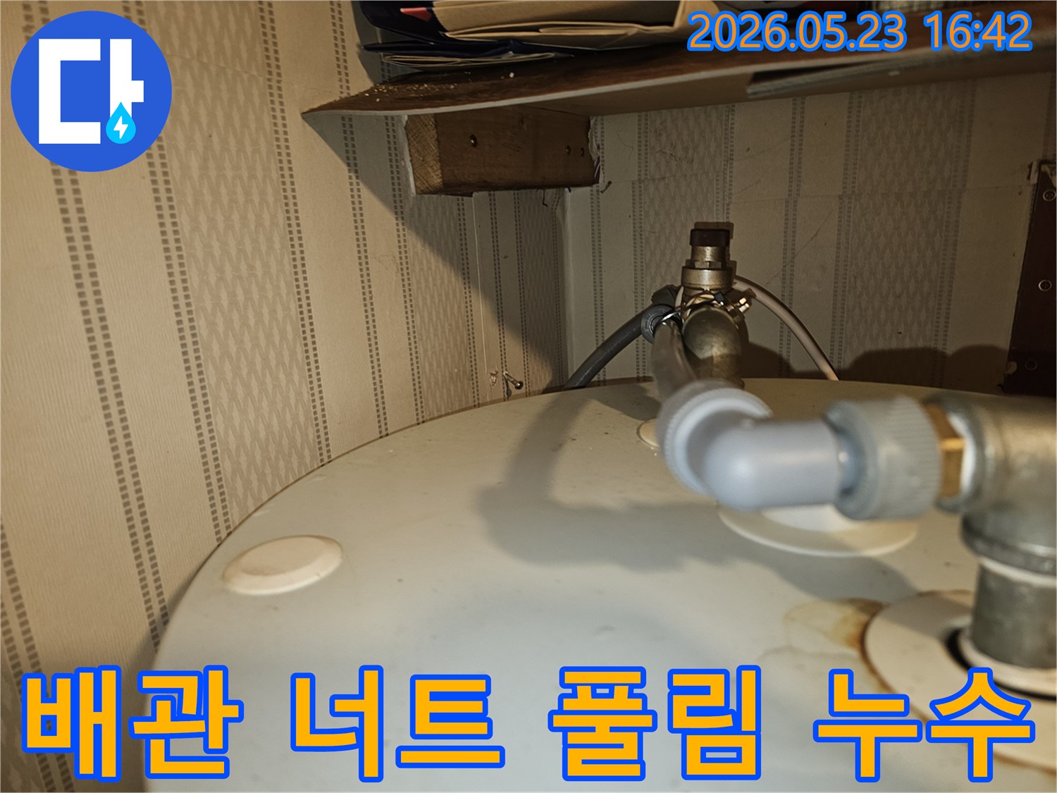 온수기-상단-배관-연결부의-너트가-풀려-물이-새어-나오는-모습을-보여주는-누수-현장-사진
