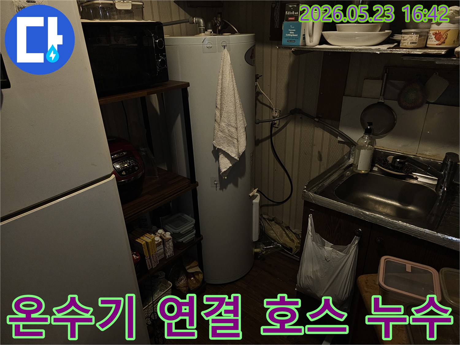 온수기 하단-연결-호스에서-발생한-누수-현장을-정밀하게-점검하는-모습