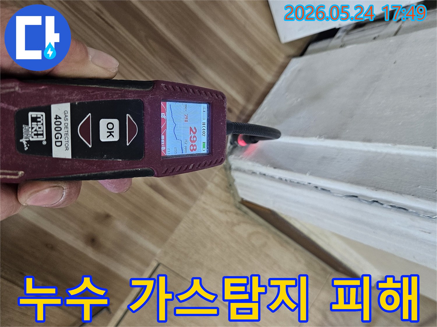누수 엔지니어가 가스 탐지기를 사용하여 벽면과 바닥 경계에서 누수 반응을 정밀하게 확인하고 있습니다.
