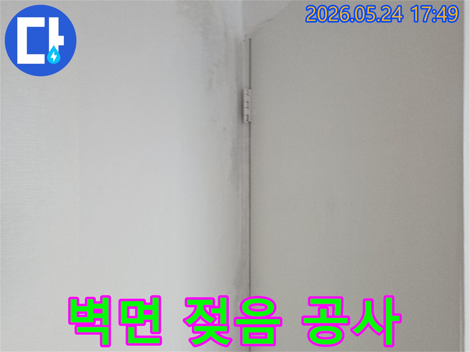 벽면 상단에 물기가 스며들어 벽지가 축축하게 젖고 있는 모습-누수 발생을 알리는 명확한 신호입니다.