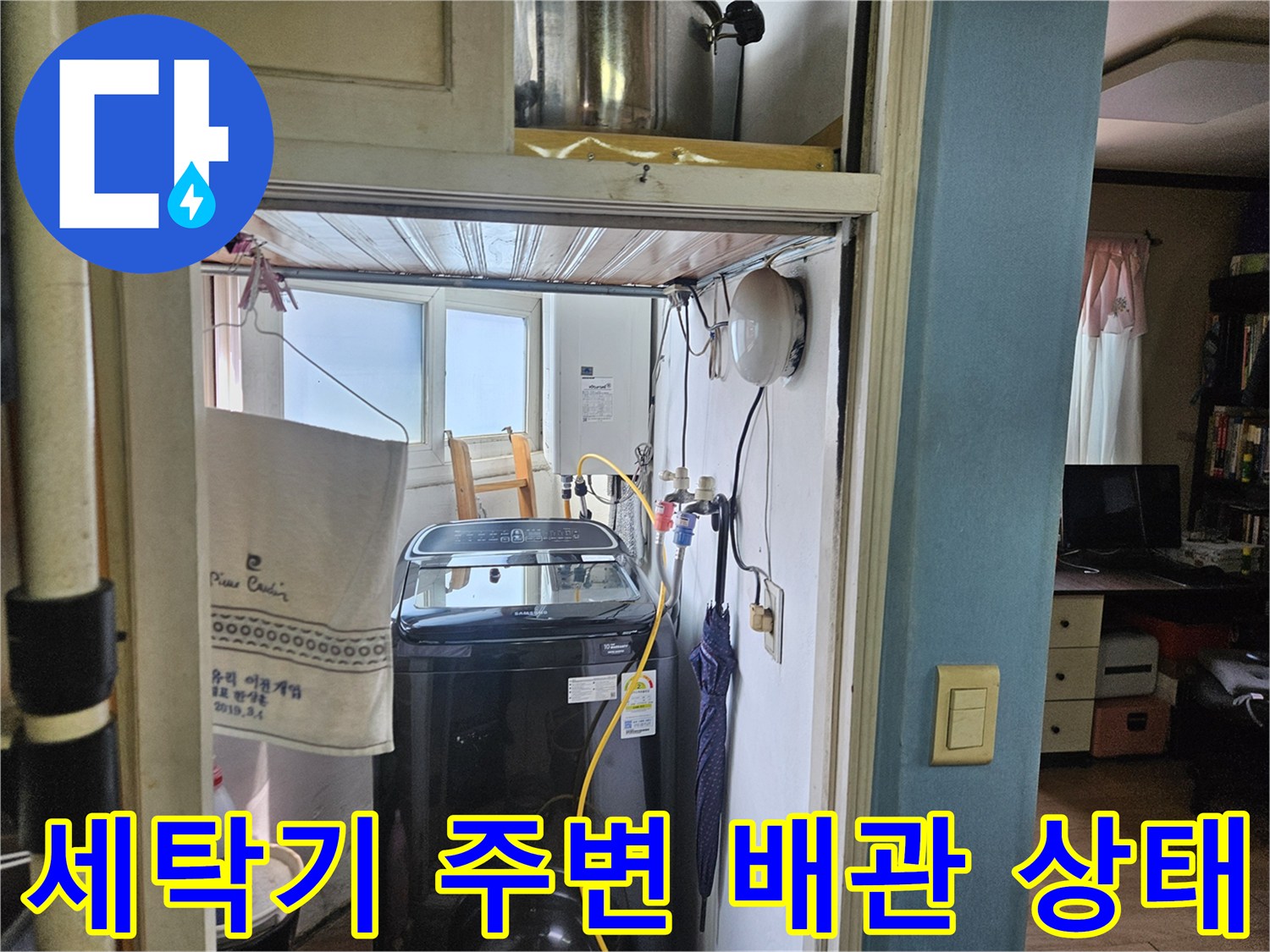 세탁기가 설치된 다용도실 내부의 수도 연결 부위와 벽면 배관 모습