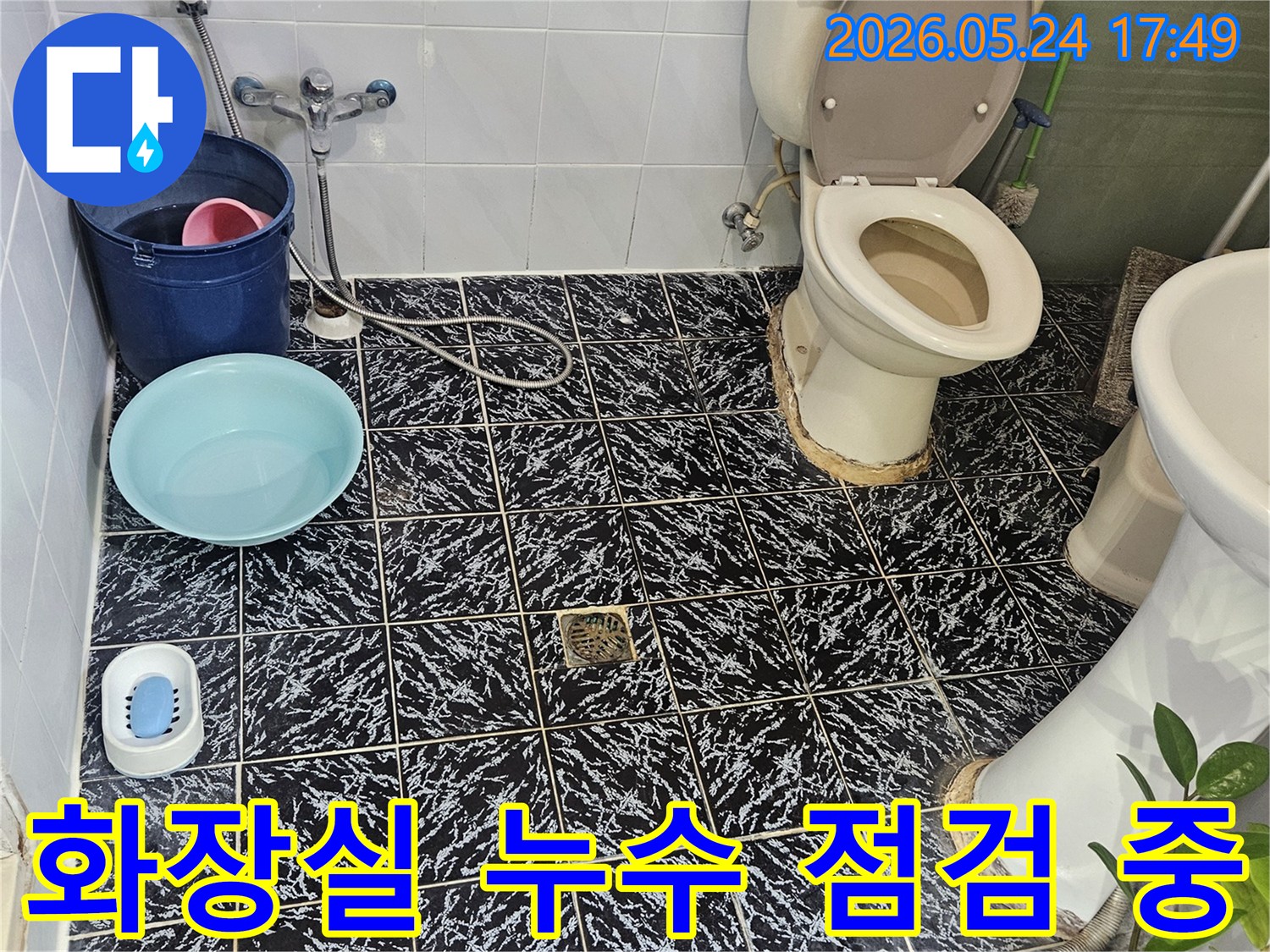 화장실 변기 주변에서-발생한 누수를-전문가가 면밀히 점검하고 있습니다