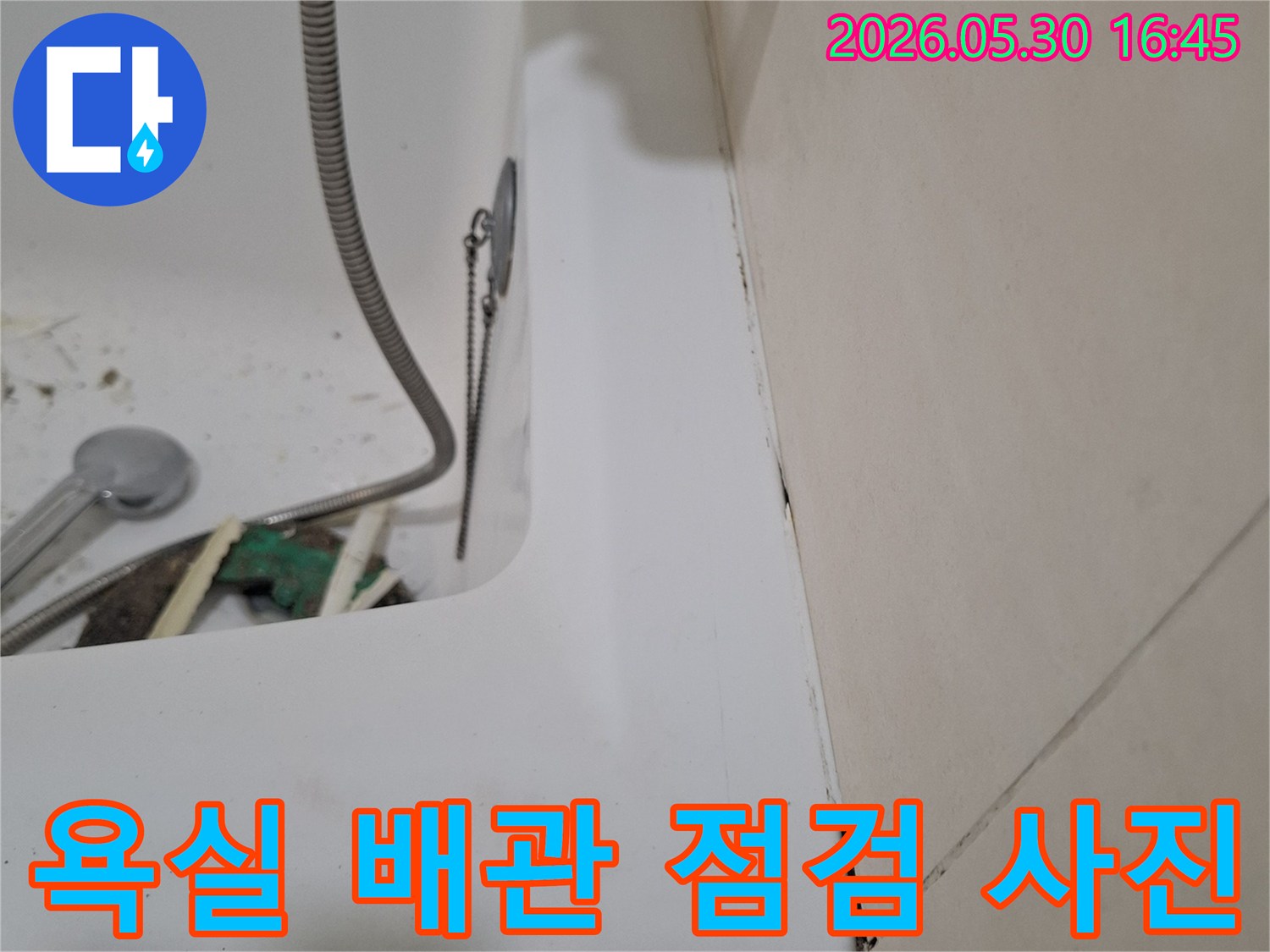 광명시 아파트 욕실에서-배관 누수 여부를-확인하기 위해-점검 중인-모습을 담은 이미지입니다