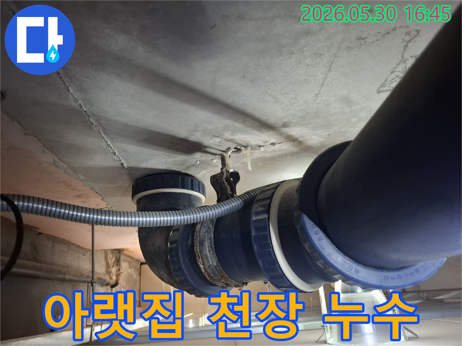 아파트 천장 아래-설치된 배수관 주변에서-발생한 물방울과-오염 흔적을-보여주는 이미지입니다.