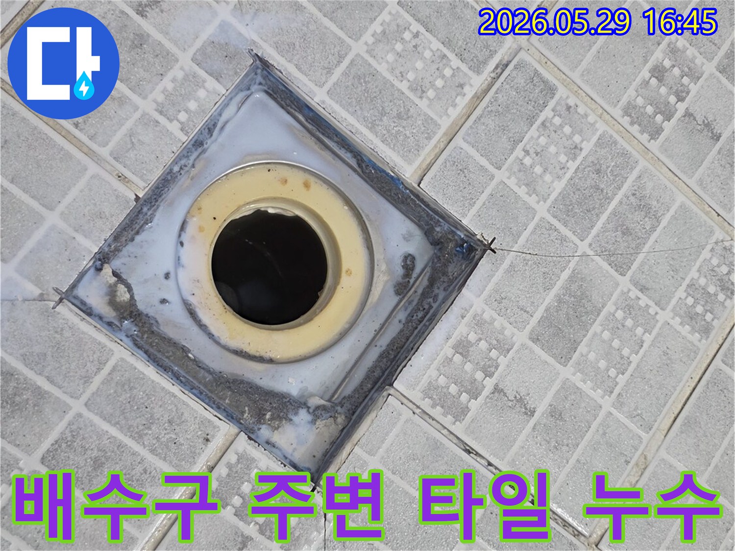 배수구 주변 타일이 깨지고-틈새가 벌어져 누수가 발생한 현장을 보여주는 이미지