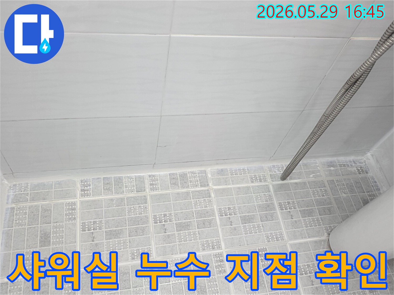 샤워실-내부의-벽면과-바닥-타일-경계면에서-누수-발생-가능성을-점검하는-모습