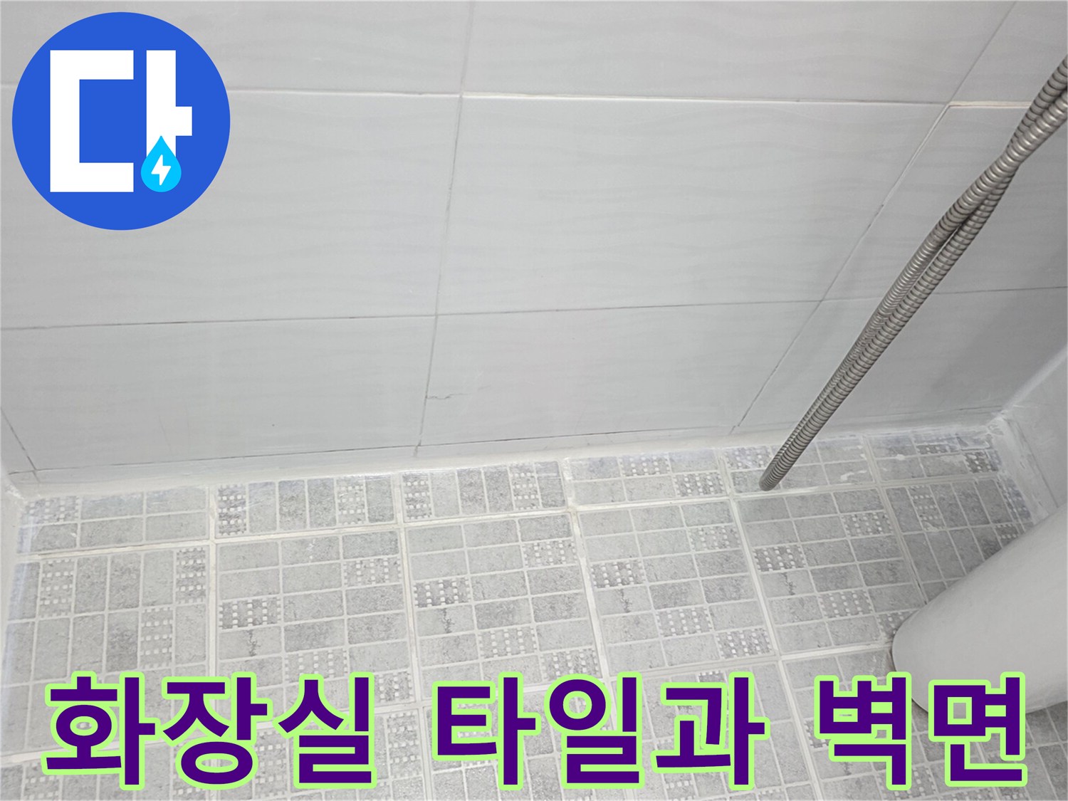 하얀색 타일로 마감된 화장실 내부의 바닥과 샤워기 호스 상세 사진입니다.