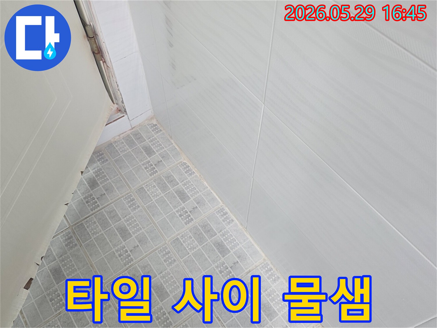 화장실 문틀 하단과 벽면 타일 경계에서-오랜 기간 물이 새어 발생한 오염을 확인할 수 있습니다.