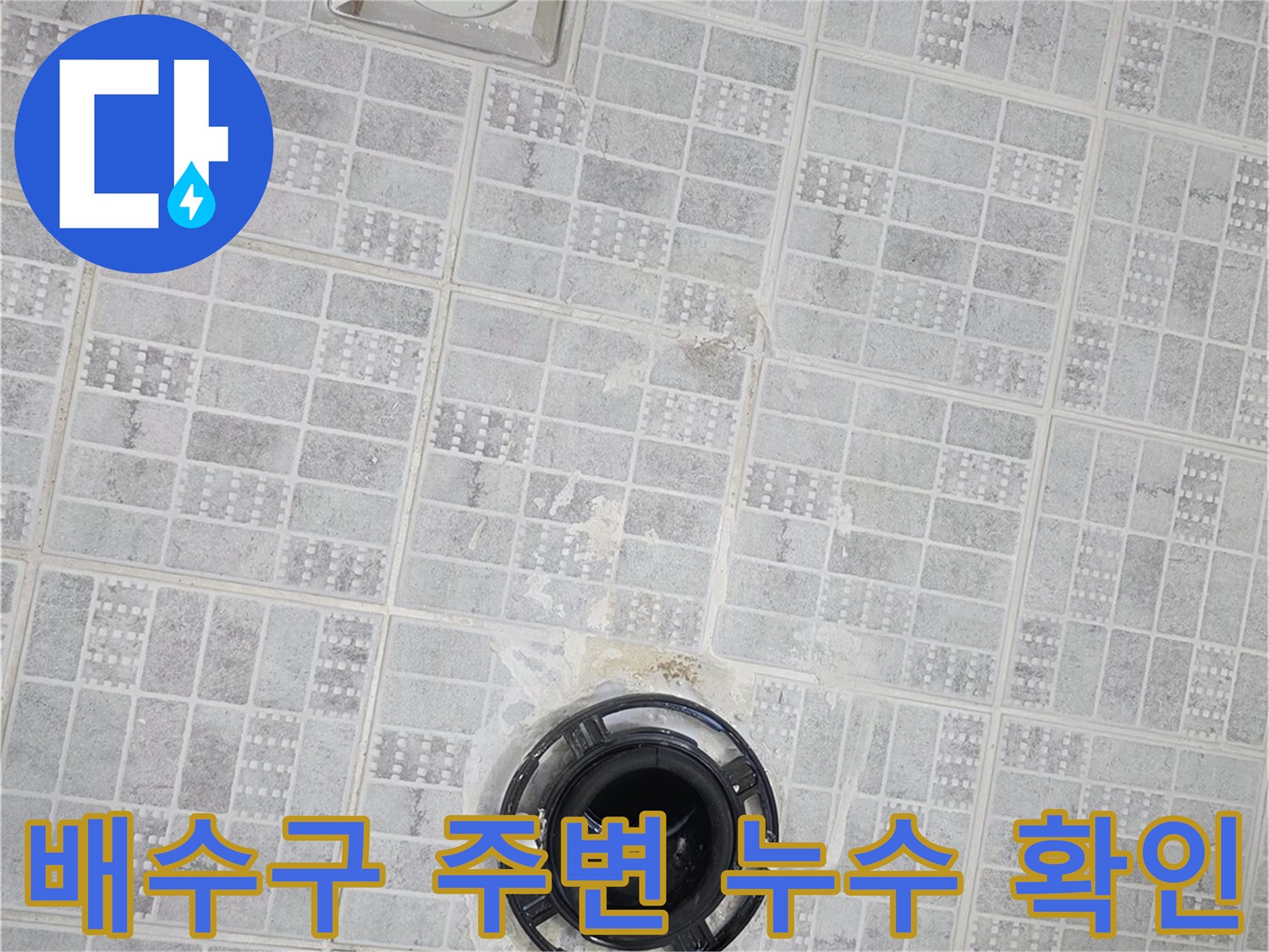 화장실 배수구와 타일 사이의 틈새를 클로즈업한 사진입니다.
